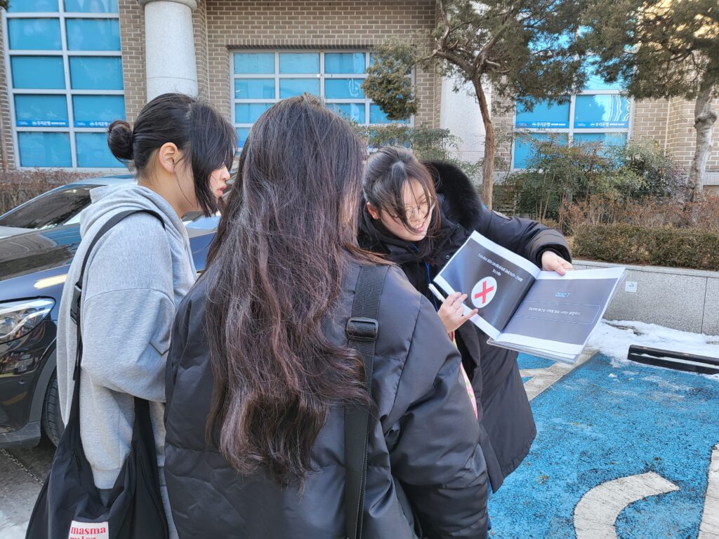 공익활동가학교 참가자가 행인 두명에게 퀴즈 답변을 설명하고 있다.