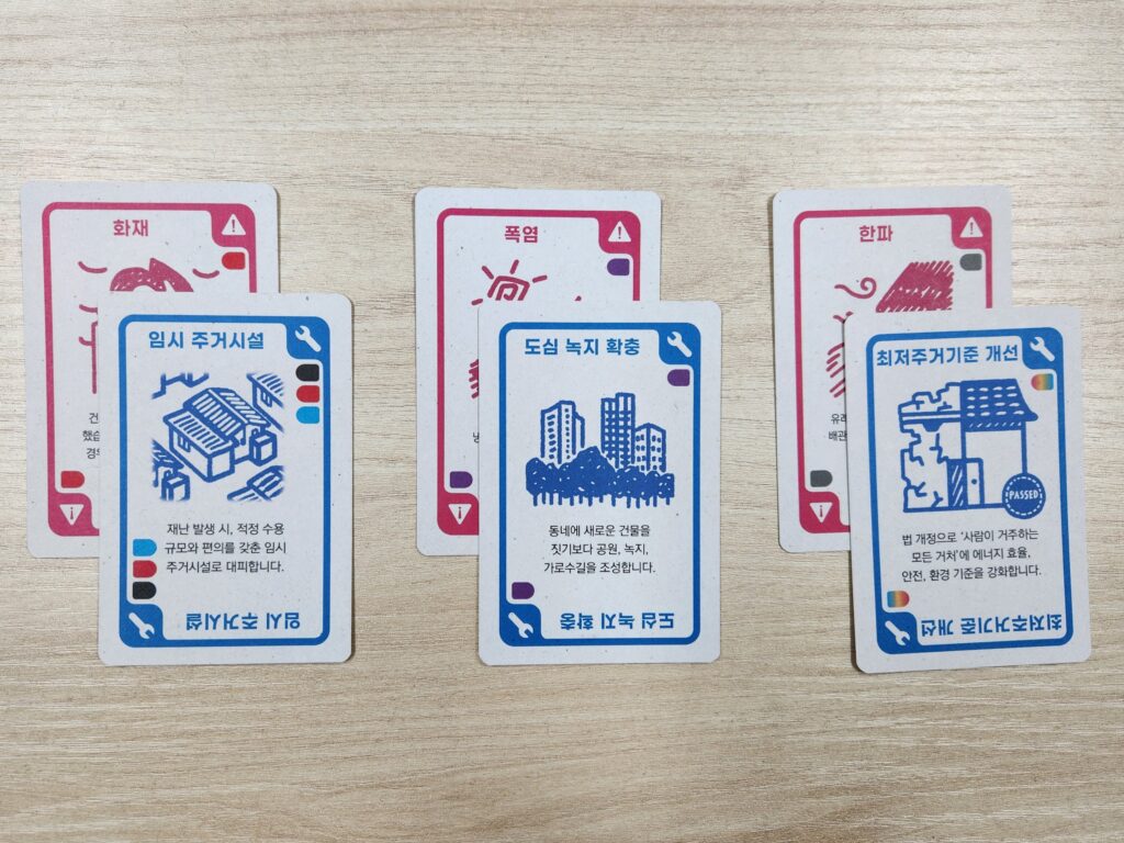 각 재난을 막는 대안카드가 겹쳐져 놓여있다. 화재-임시 주거시설 / 폭염 -도심녹지확충 / 한파-최저주거기준 개선