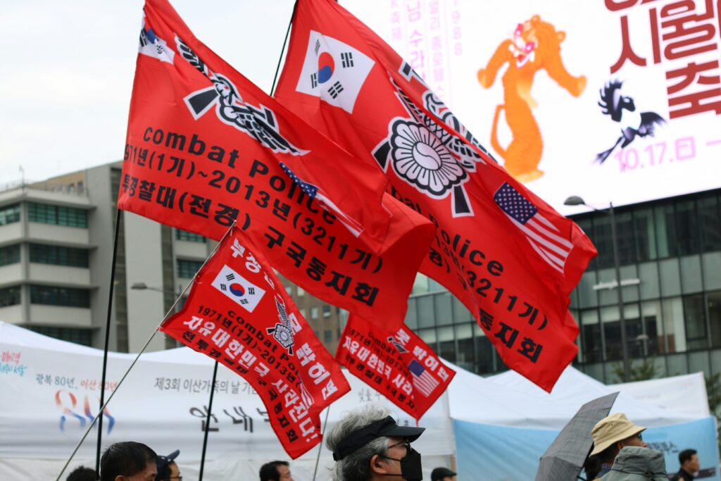 극우 집회 사진. 각종 붉은 색의 깃발들이 보인다.